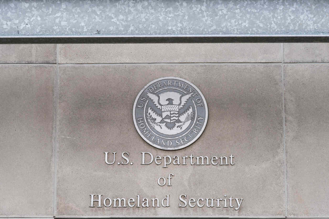 Close-up of the U.S. Department of Homeland Security seal and text on a building, symbolizing federal workers' compensation.
