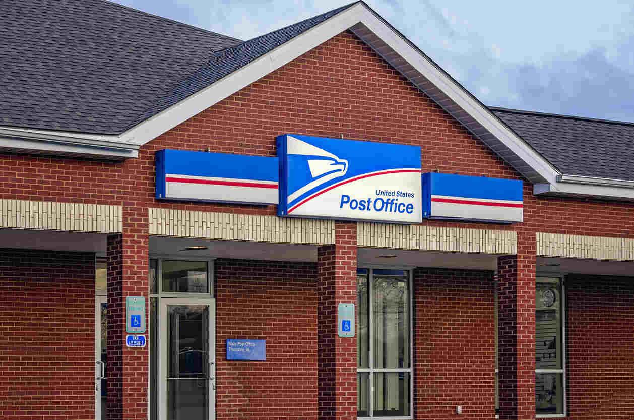 Front of a U.S. Post Office with handicap parking signs, representing federal employment and potential workers' compensation claims.